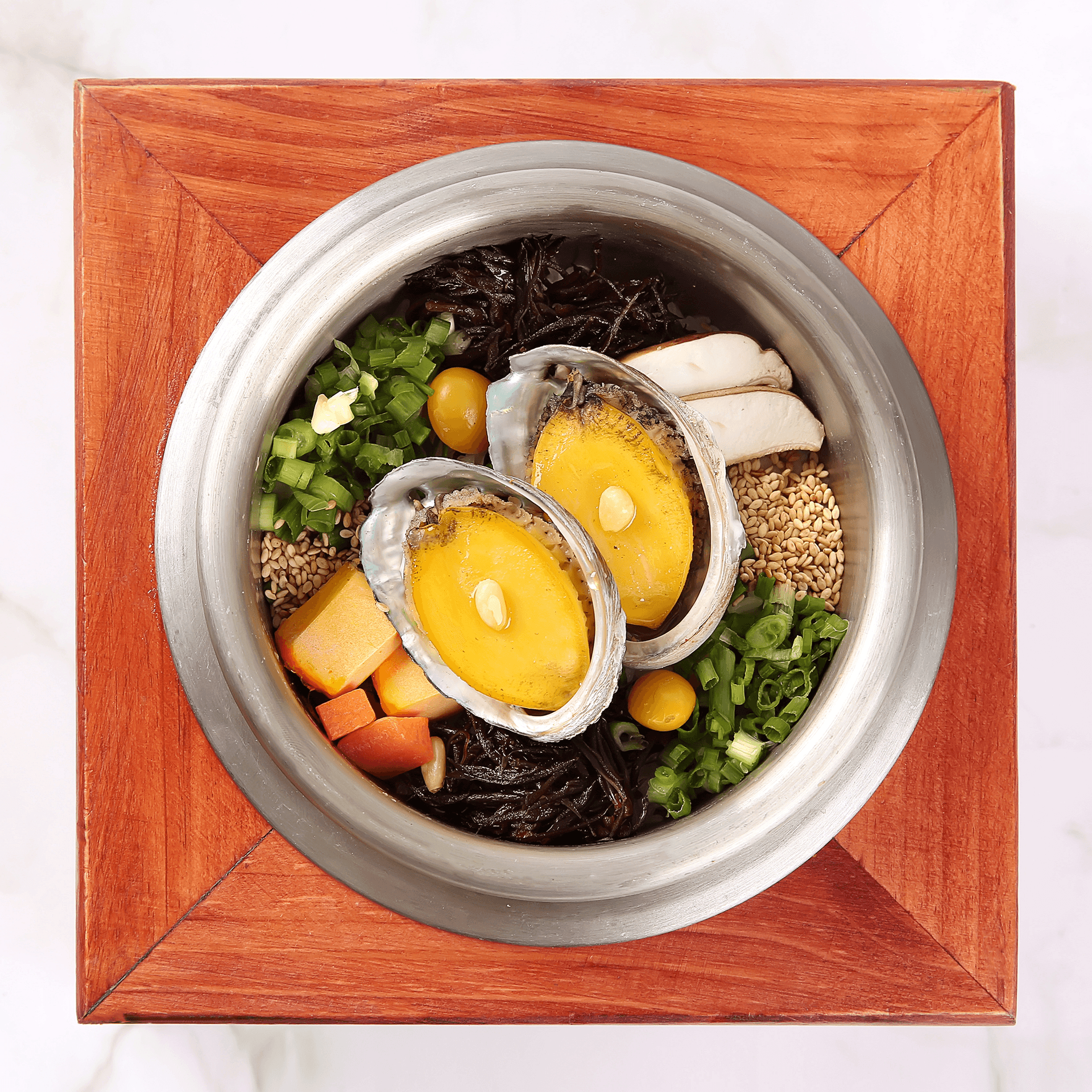칼집 낸 전복 두 마리와 버섯, 대파가 올라간 솥밥